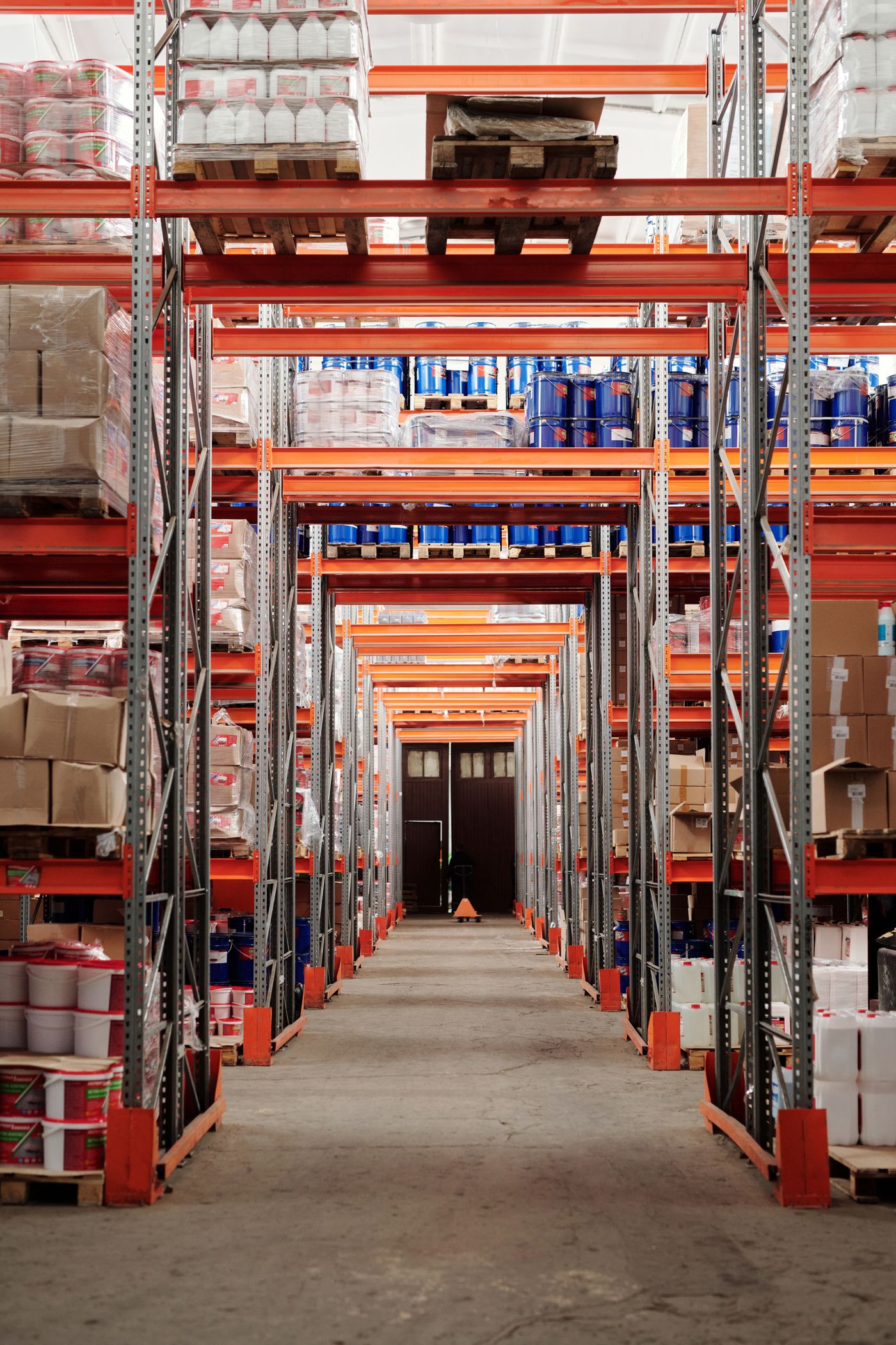 Warehouse aisle with organized shelving and palletized products ready for distribution